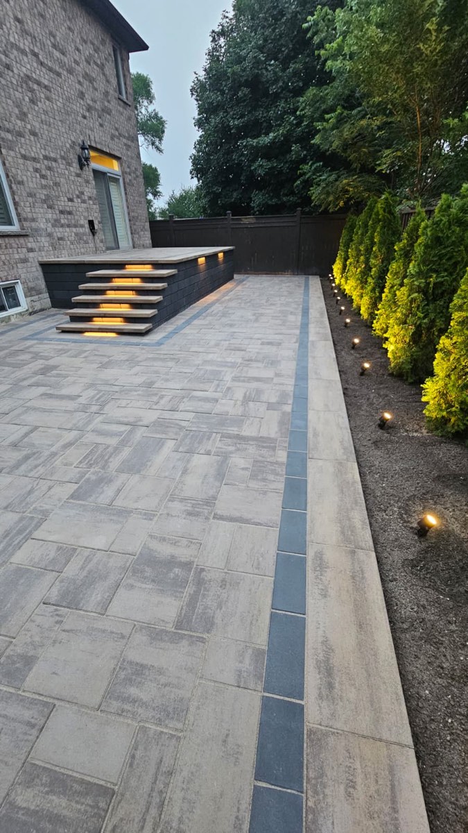 Interlocking Paver Patio with Lit Steps and Landscape Lighting