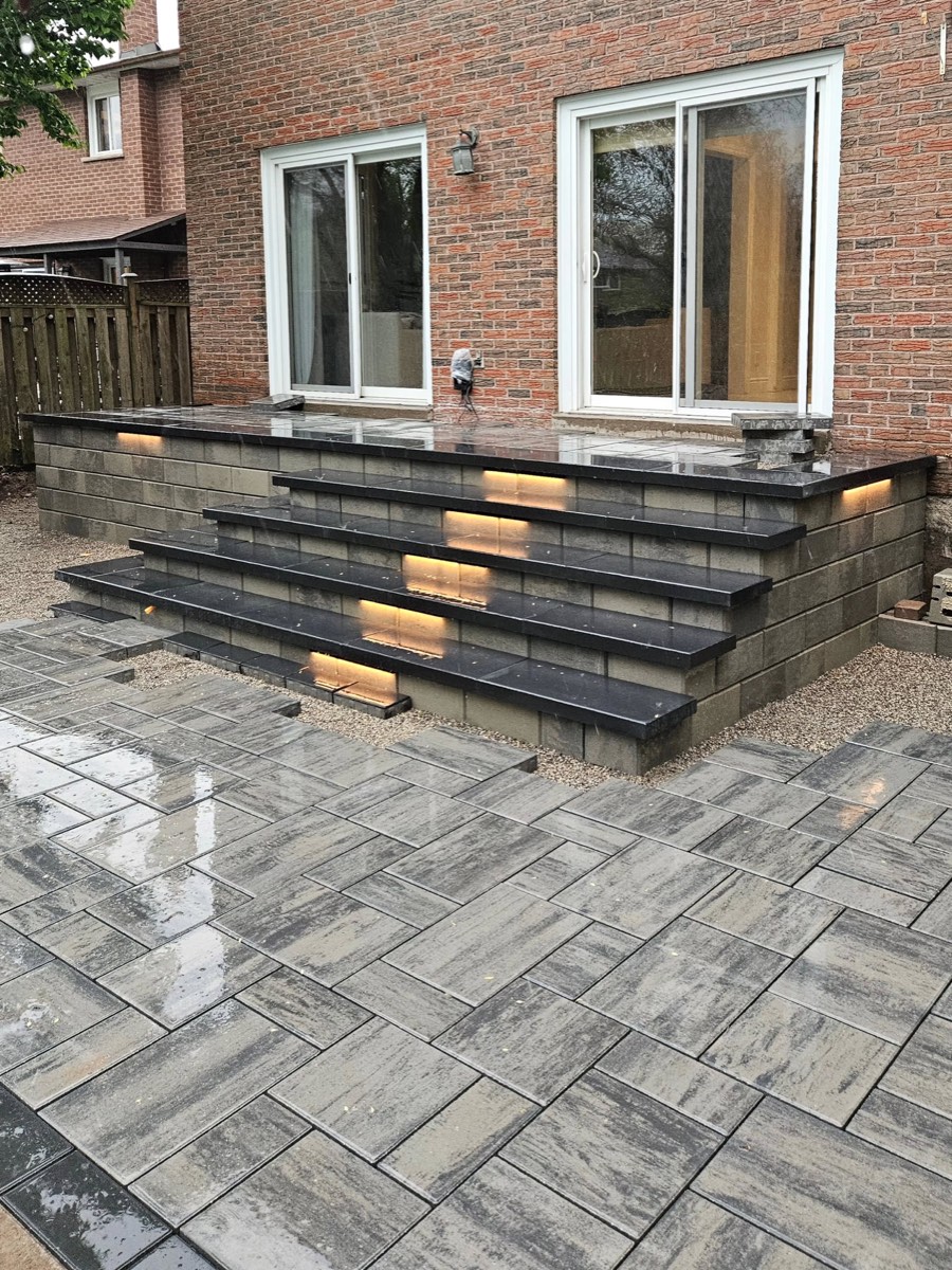 Raised Paver Patio with Lit Black Stone Steps